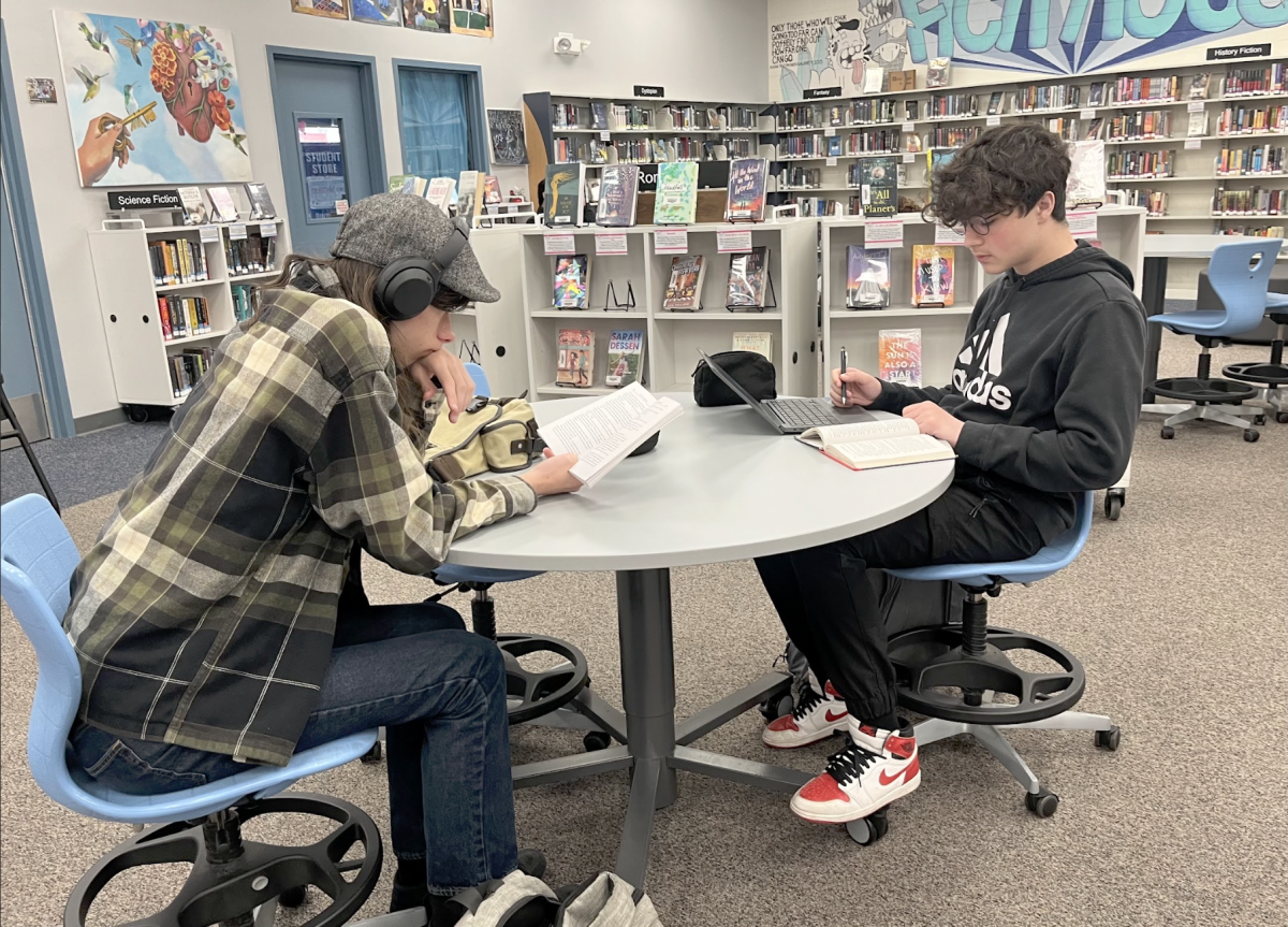 Students lounge in the UHS Library, reading books. The library offers a wide assortment of genres to choose from, including nonfiction, fantasy, history fiction, dystopian and more.